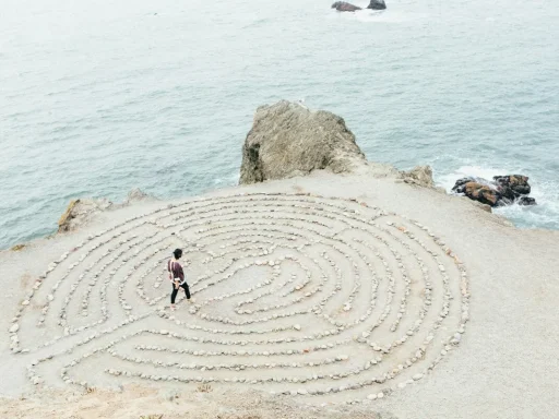Person walking through a labyrinth by the ocean, symbolizing overcoming confusion and stuckness