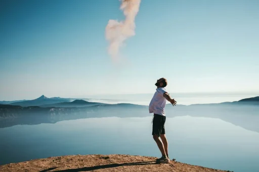 Person standing on a mountain top, feeling free and overcoming negative feelings